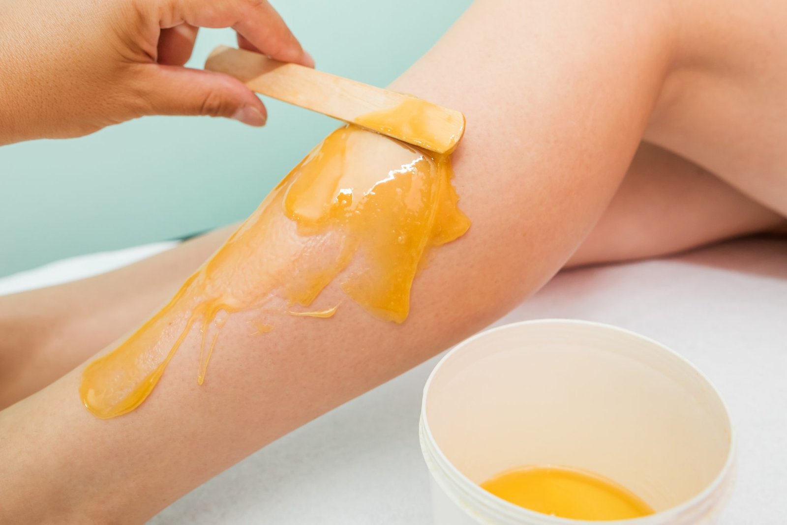 woman-undergoing-leg-hair-removal-procedure-with-sugaring-paste-salon-skin-care-remove-hair-with-sugar-paste-2048x1367